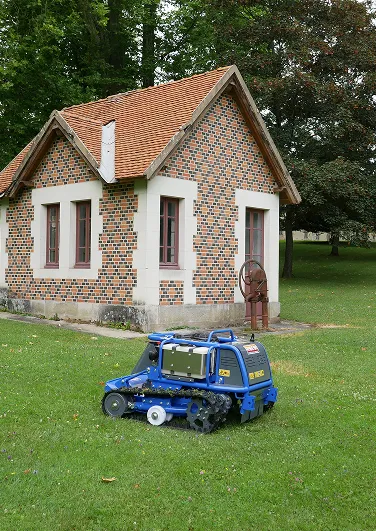 Mini-chargeur bleu devant maison